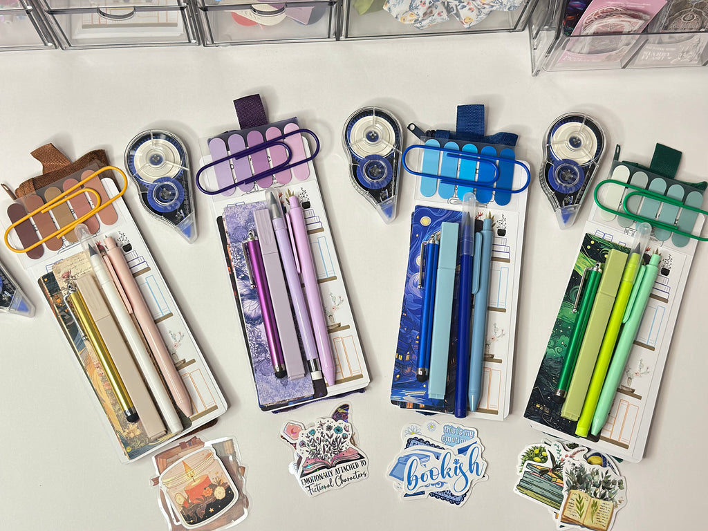 Collection of stationery items including pens, markers, and stickers on a white surface.