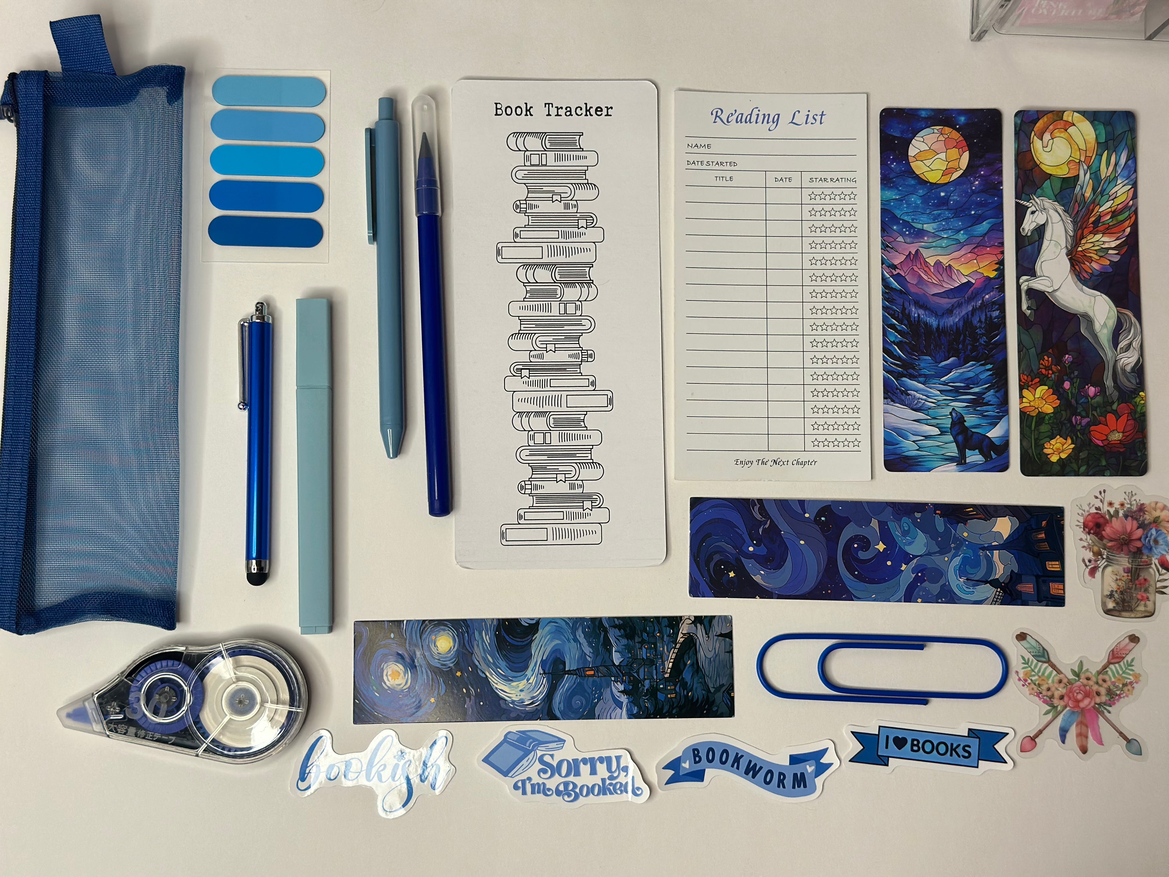 Collection of stationery items including pens, a pencil case, and decorative stickers on a white surface.