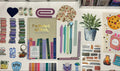 Collection of stationery items including books, pens, and decorative elements on a white surface.