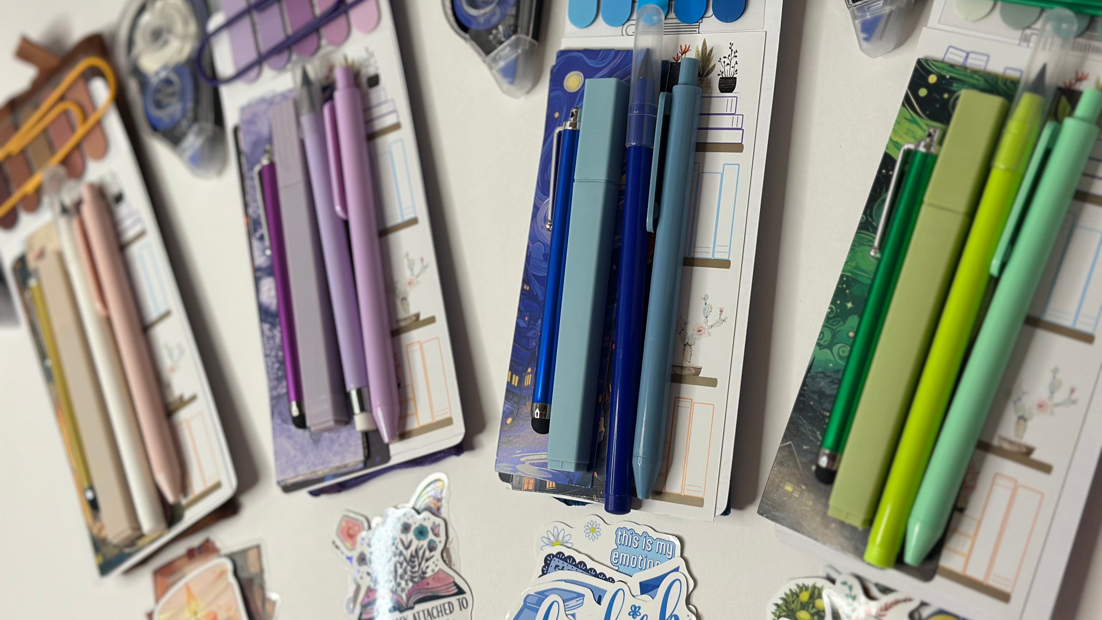 Assorted stationery items including pens, clips, and paper clips on a white surface.